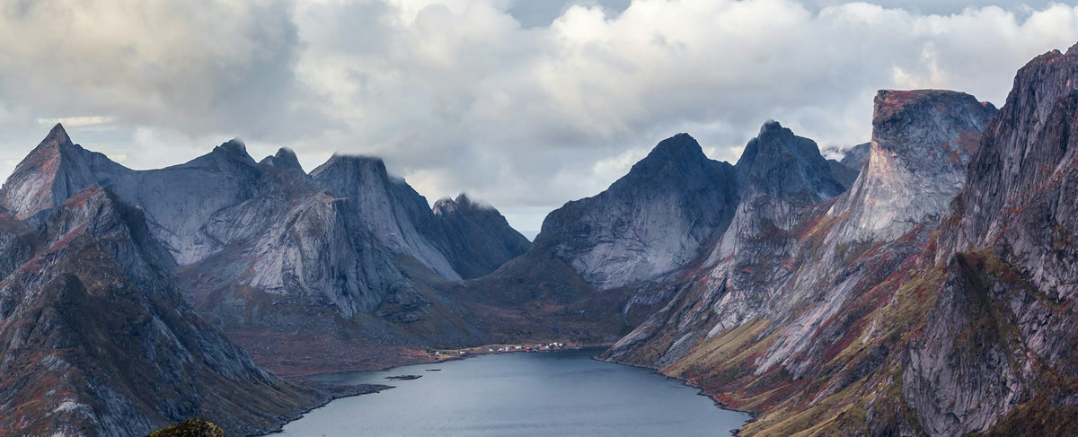 Fjord nordique aux parois abruptes plongeant dans une eau sombre sous un ciel dramatique — clin d'œil aux paysages sauvages d'Alexander Skarsgård, visage de Vendetta Uomo de Valentino, par la parfumerie Olara