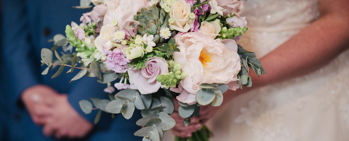 Bouquet de noiva de flores brancas e rosa nas mãos da noiva — que perfume de mulher escolher para um casamento, o guia Olara