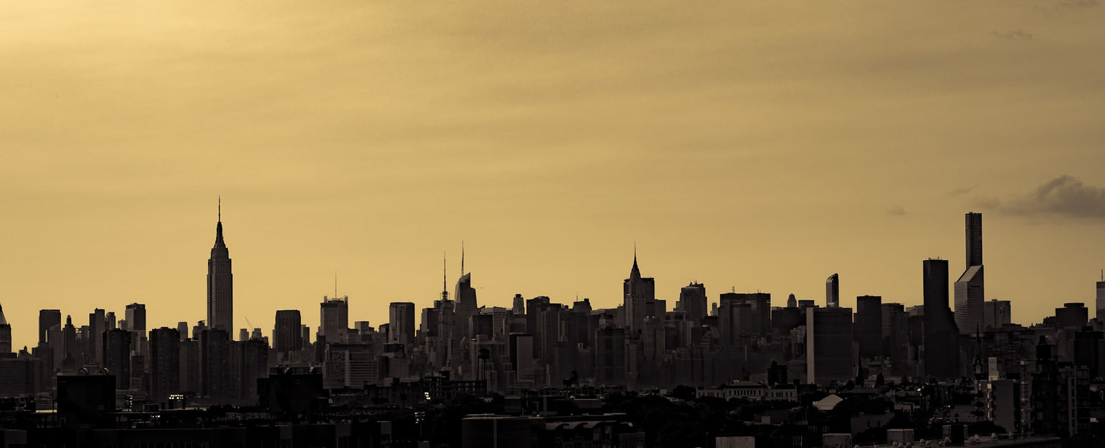 Silhouette des gratte-ciel de Manhattan au crépuscule — New York, berceau d'Estée Lauder et de la ligne Re-Nutriv, chez Olara