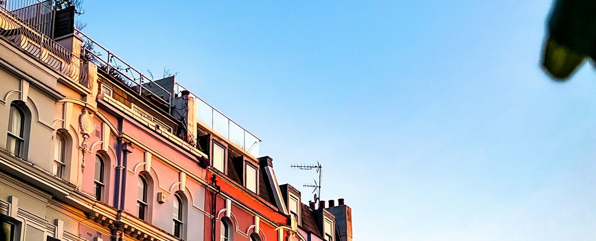 Pastel facades of Notting Hill houses in London under a blue sky — the romantic universe of Julia Roberts, face of Lancôme's La Vie Est Belle, by the Olara perfumery