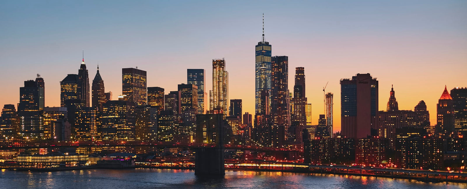 Le pont de Brooklyn et la skyline de New York à l'heure bleue — la ville natale de l'apothicaire Kiehl's depuis 1851, chez Olara