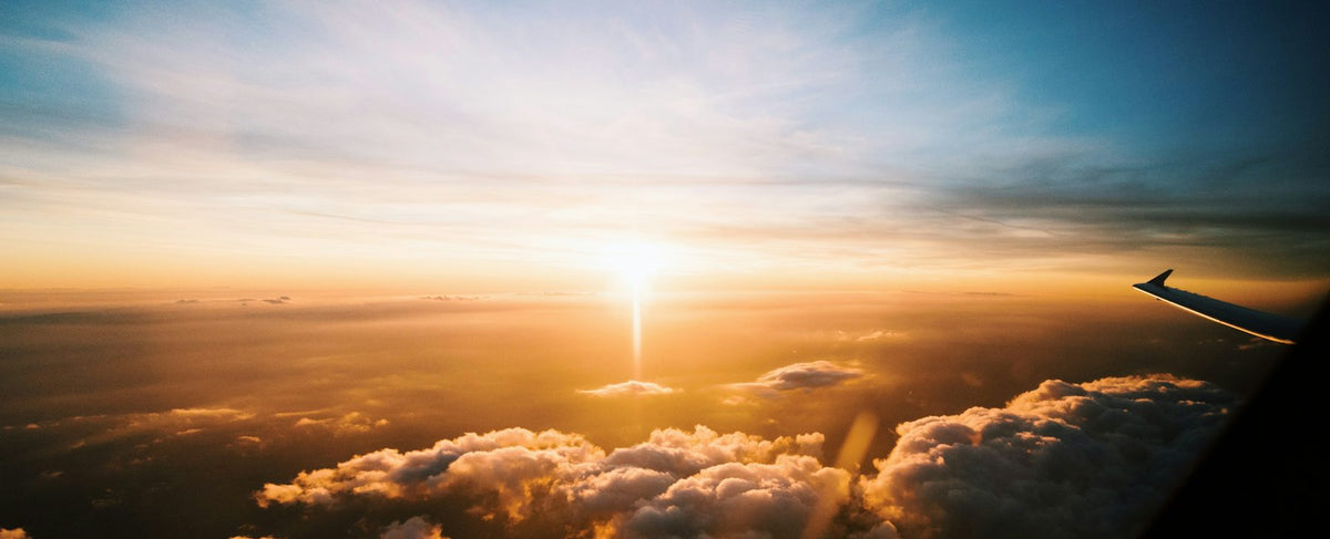 Mar de nuvens dourado ao pôr do sol visto de cima — a altitude e a velocidade do universo de Tom Cruise, em torno de Boss Bottled da Hugo Boss, pela perfumaria Olara