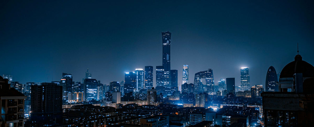 Gratte-ciel illuminés dans la nuit — la ville verticale et nocturne du Chevalier noir et l'univers de Christian Bale, autour de Noir Extrême de Tom Ford, par la parfumerie Olara
