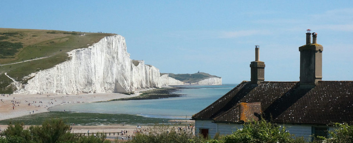 Falaises de craie blanches et plage balayée par le vent sur la côte anglaise — l'élégance britannique de Colin Firth et l'univers de Wood Sage & Sea Salt de Jo Malone London, par la parfumerie Olara