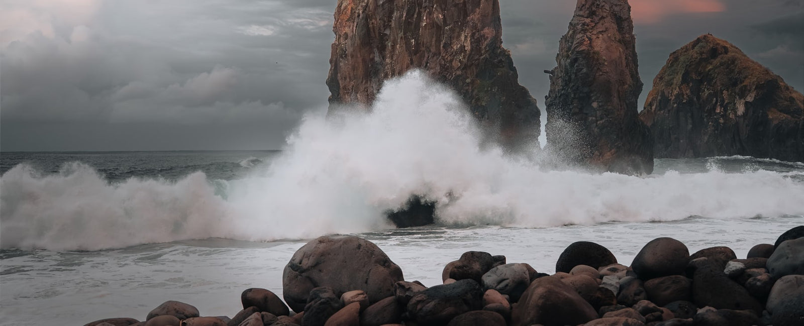 Olas del océano contra las rocas bajo un cielo dramático — el universo marino de Le Sel d'Issey de Issey Miyake en Olara