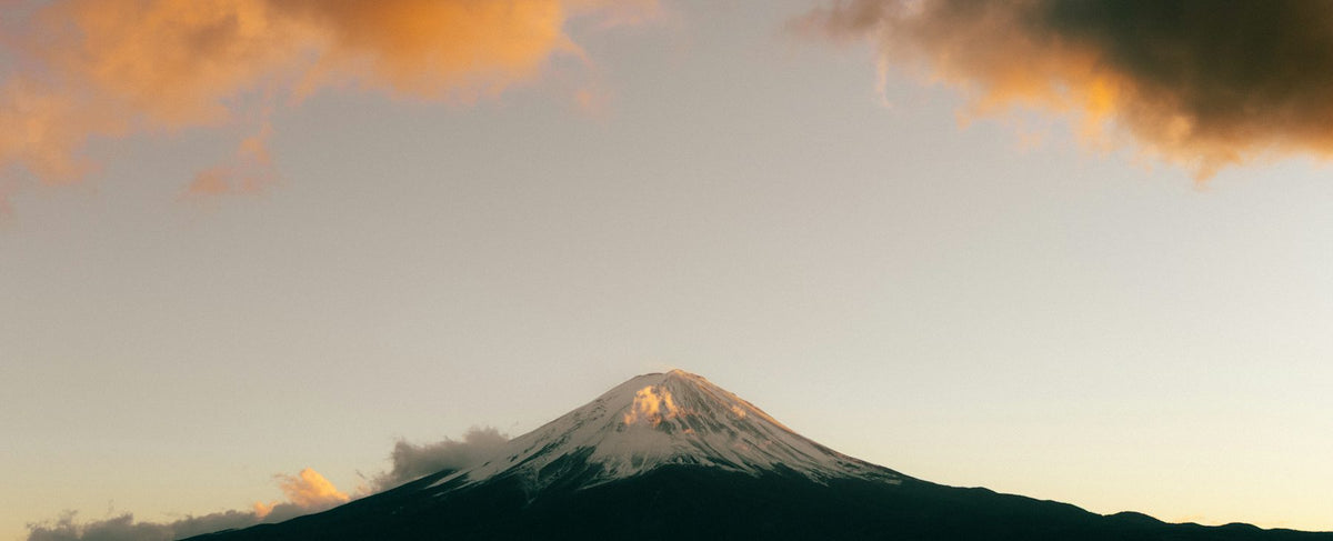 Mont Fuji enneigé au lever du soleil dans des nuages roses — l'élégance japonaise de Clé de Peau Beauté, nouvelle maison de la parfumerie Olara