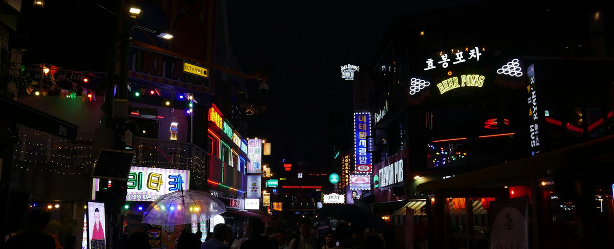 Rue de Séoul la nuit, enseignes au néon illuminées — l'univers audacieux de Born to Stand Out chez la parfumerie Olara