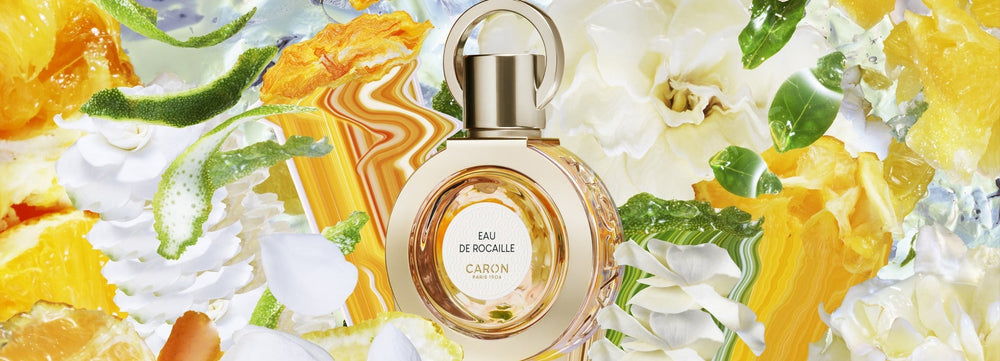 Le flacon d’Eau de Rocaille parmi fleurs blanches et agrumes