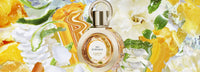 Le flacon d’Eau de Rocaille parmi fleurs blanches et agrumes