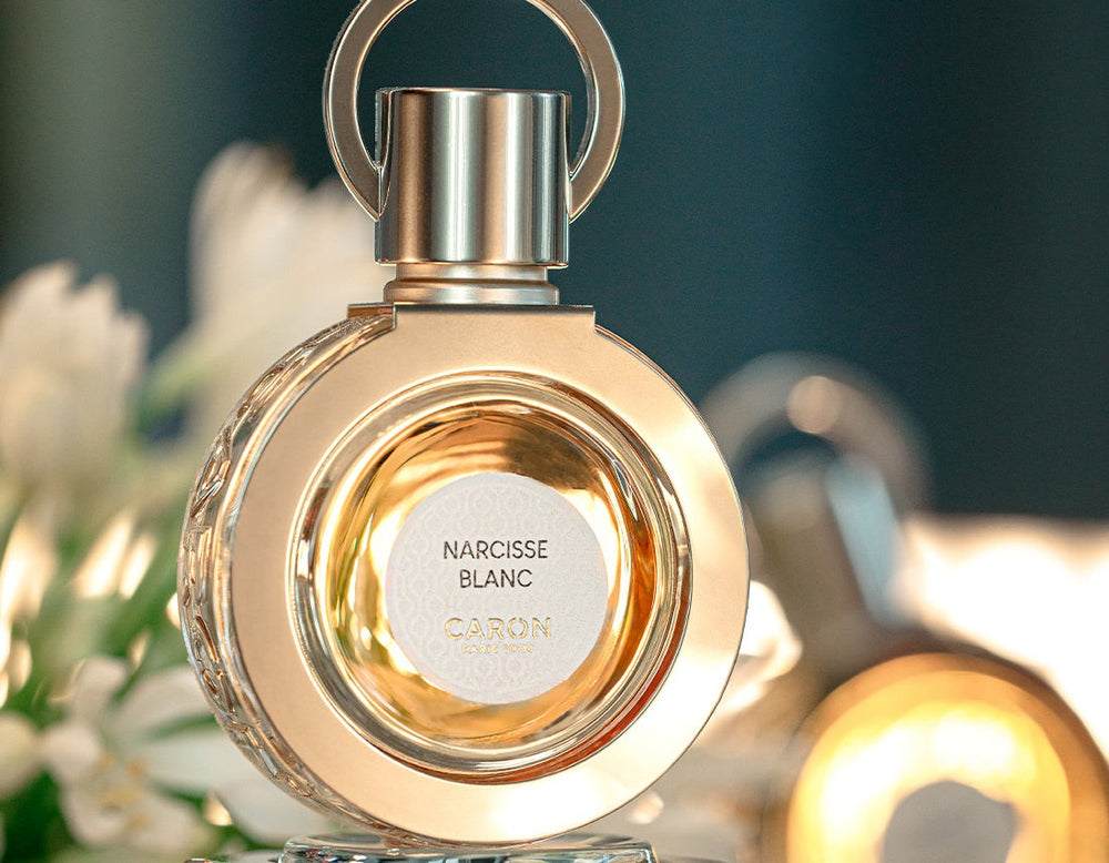 Le flacon de Narcisse Blanc en gros plan parmi les fleurs blanches