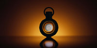Le flacon d’Oud Excelsa en contre-jour sur fond ambré