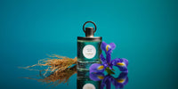 Le flacon de Vétiver Infini entre racines de vétiver et iris